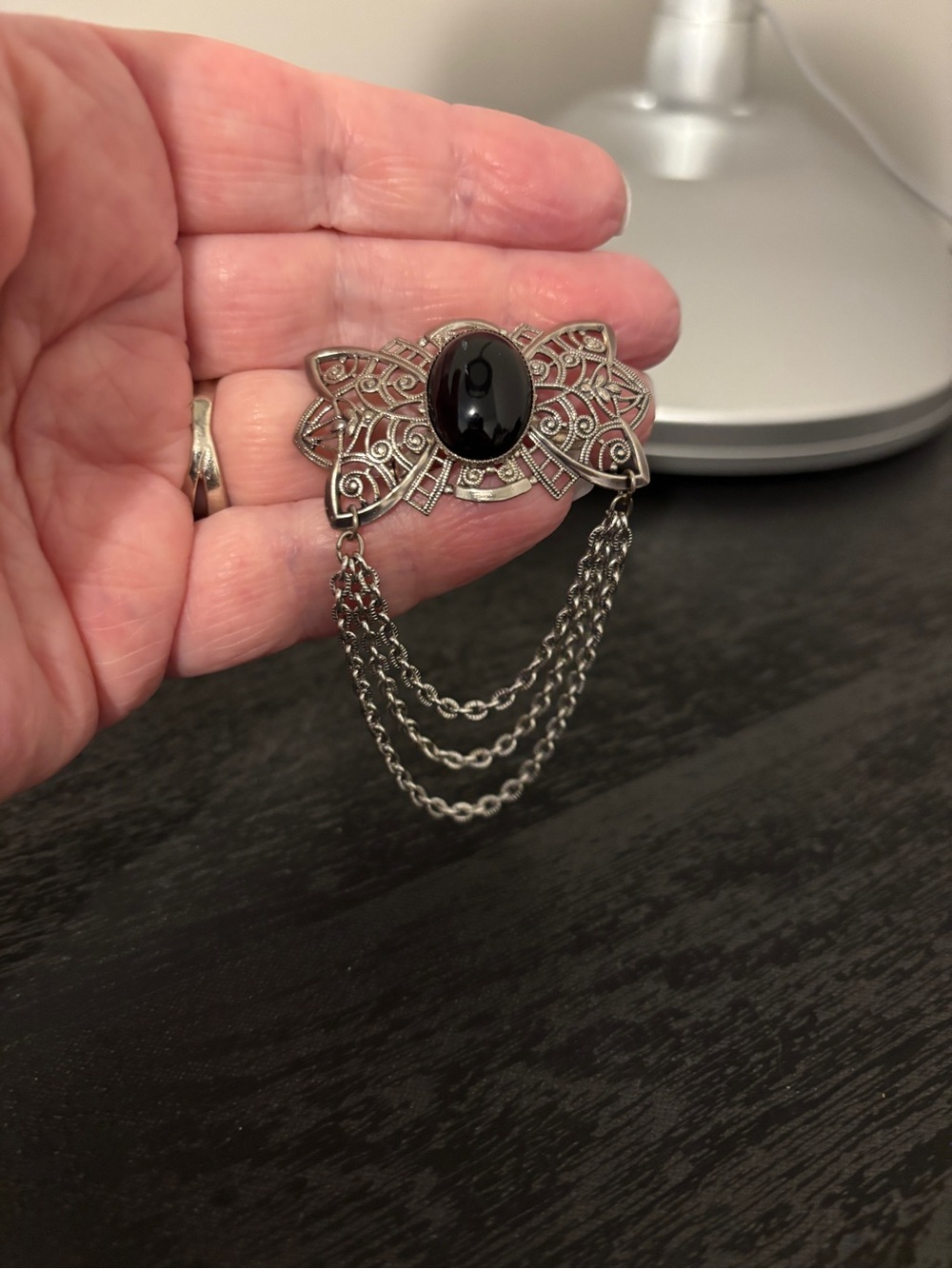Vintage-Inspired Silver Brooch with Black Stone and Chain Accent